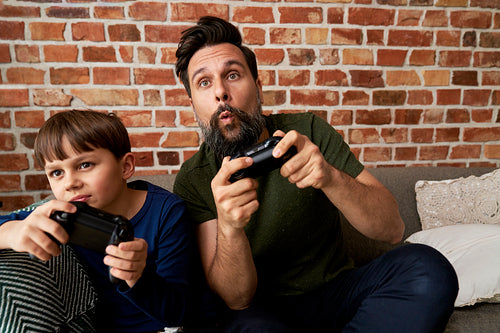 Focused father and son while playing video game
