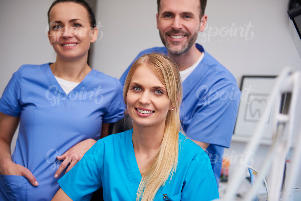 Team of smiling and satisfied dentists in dentist's office