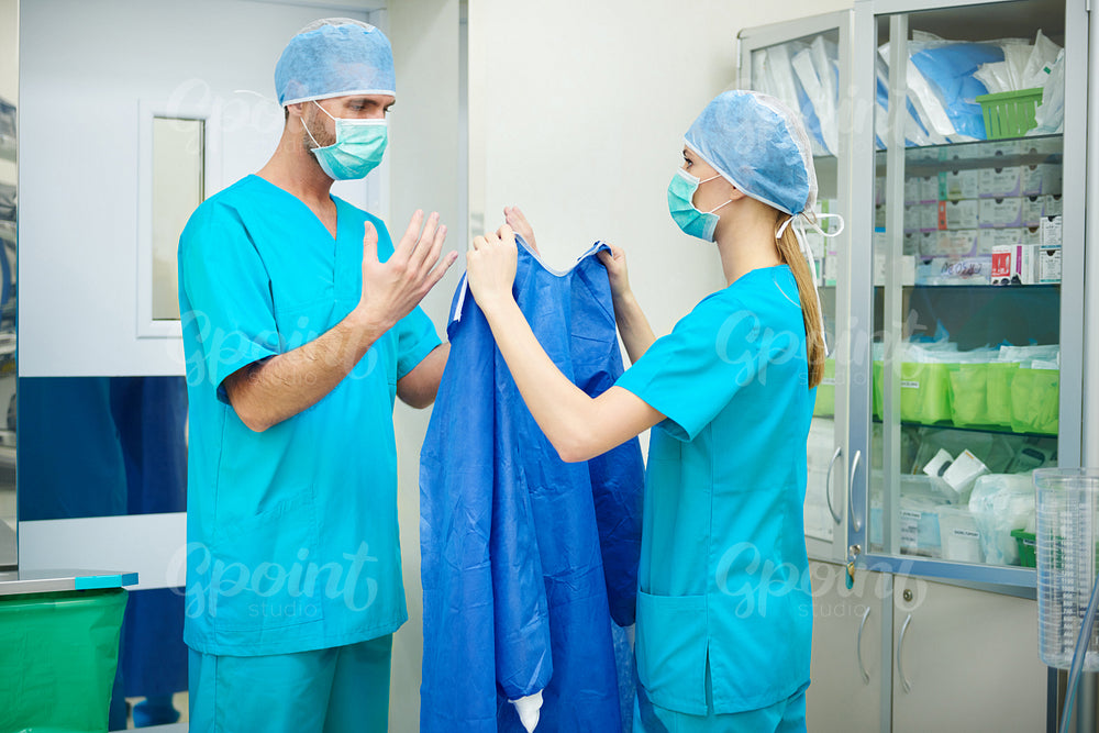 Nurse helping surgeon before the operation