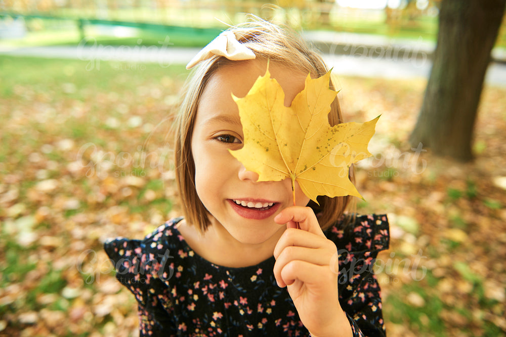 Portrait of happy girl with autumnal leafs