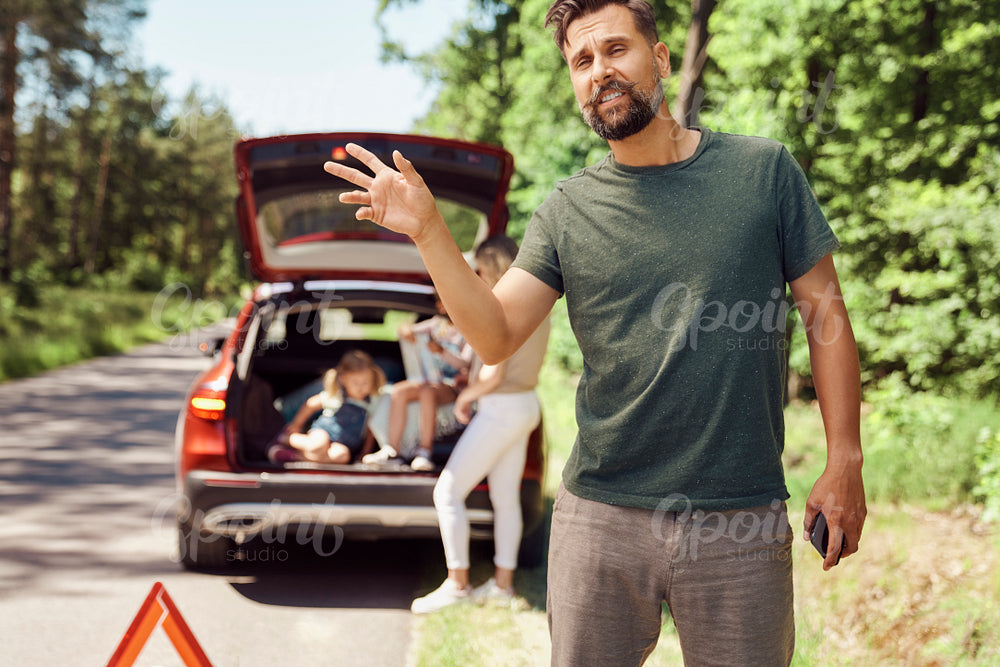 Man with family with broken car on the road