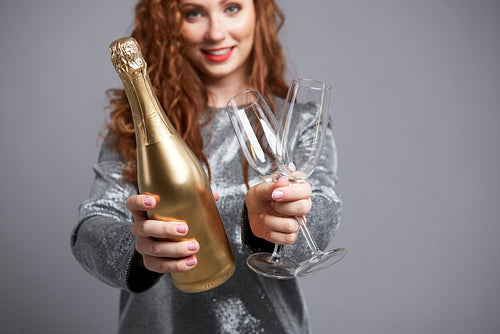 Woman holding champagne flute and bottle