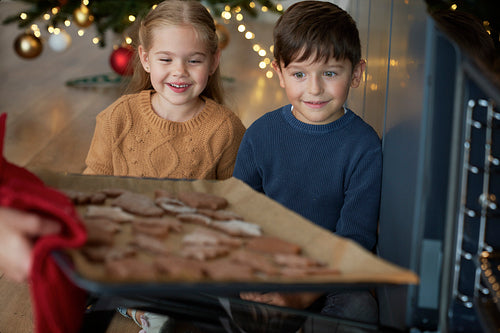 Children cannot wait to eat freshly baked gingerbread cookies