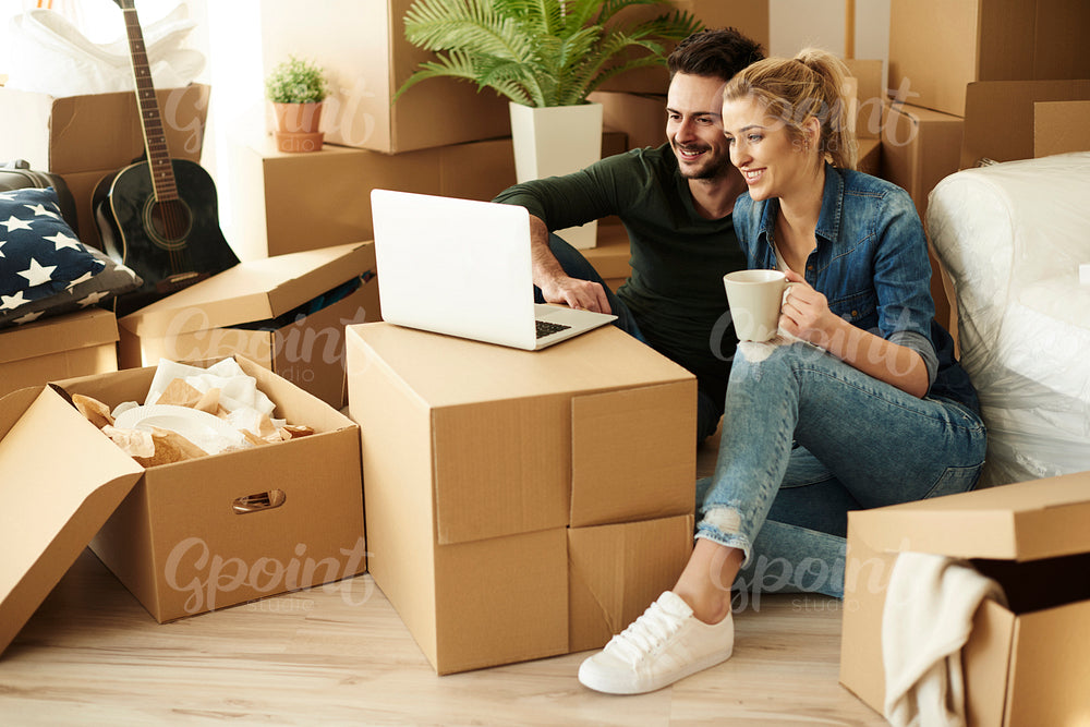 Couple sitting on the floor with laptop