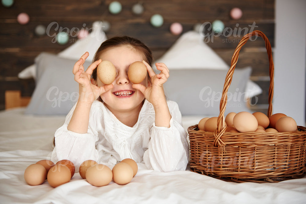 Girl holding eggs in front of her eyes