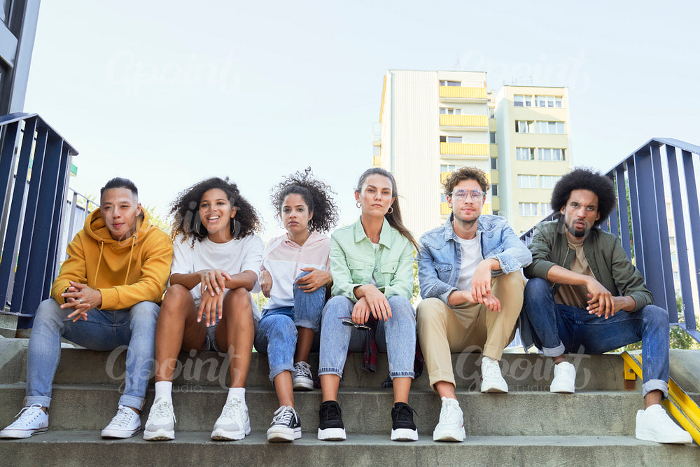 Group of young people sitting in a row on the stairs