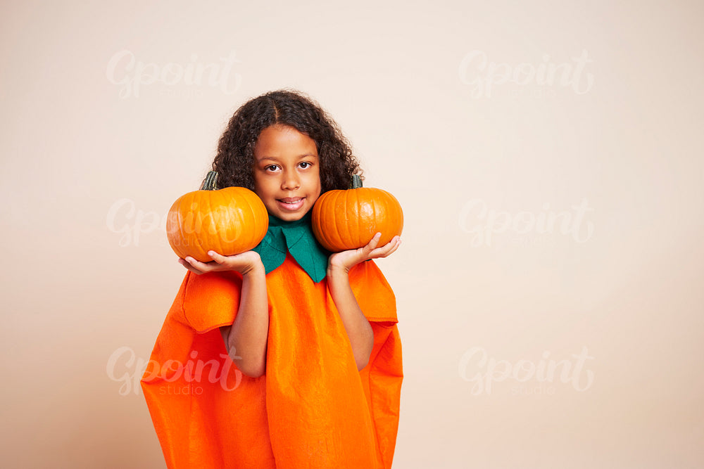 Portrait of African girl holding two halloween pumpkins