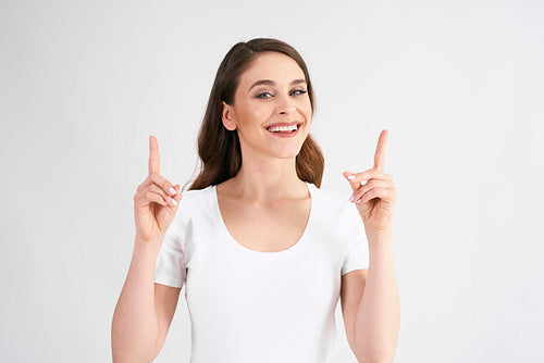 Smiling woman pointing at copy space