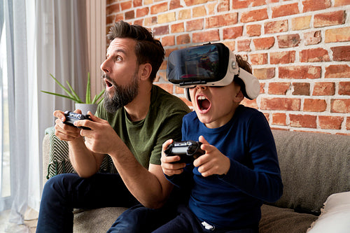 Excited father and son during playing video game at home