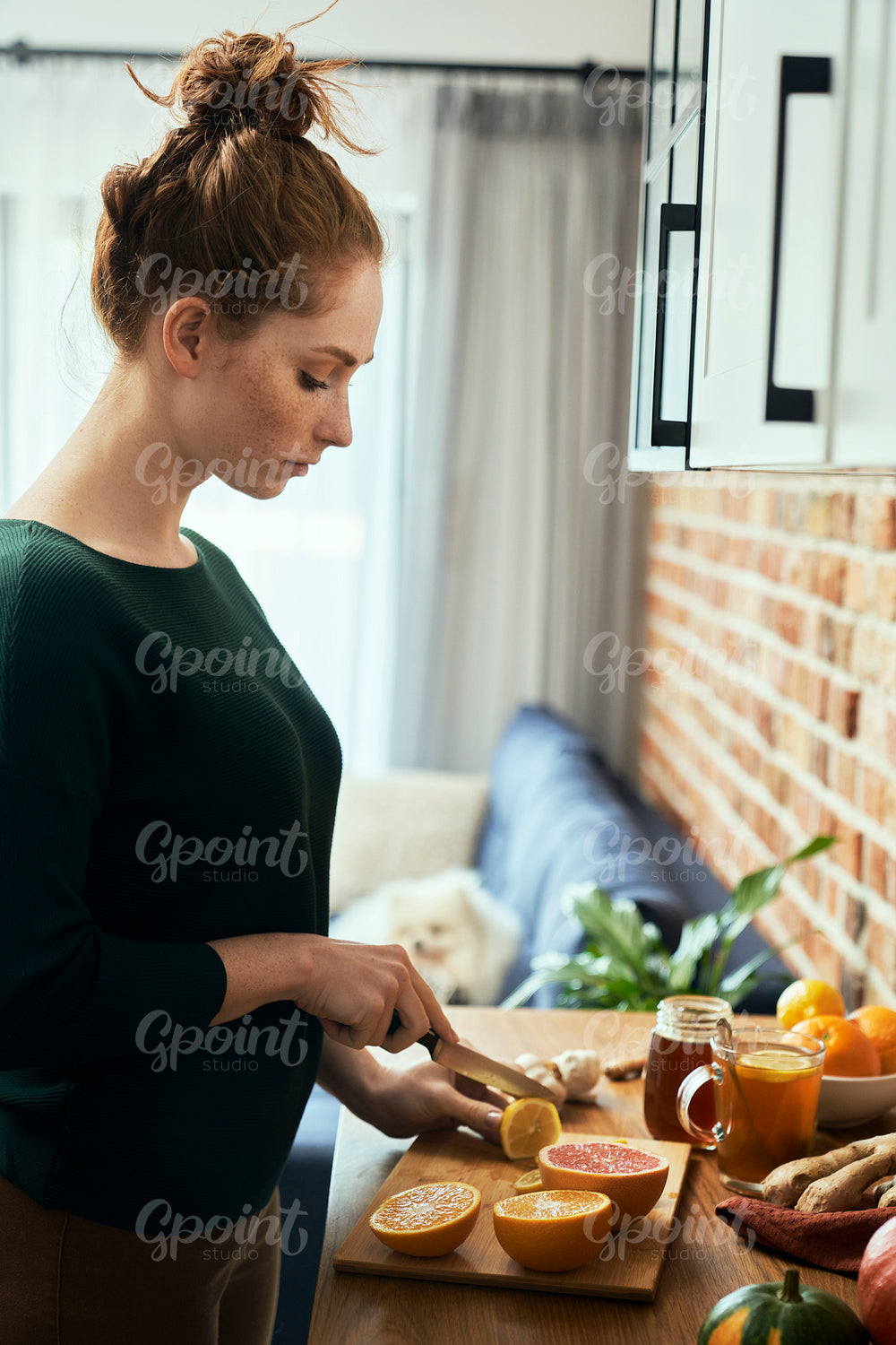 Caucasian young woman cutting lemon for winter tea