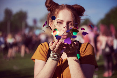 Girl blowing some confetti pieces