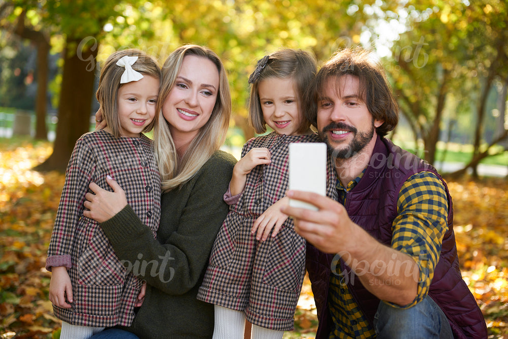 Family with two children making a selfie in autumn woods