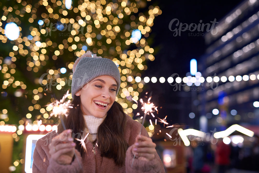 Attractive woman with sparklers on Christmas market