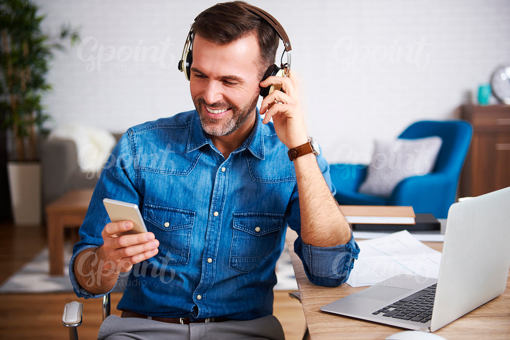 Happy man listening to music and using mobile phone