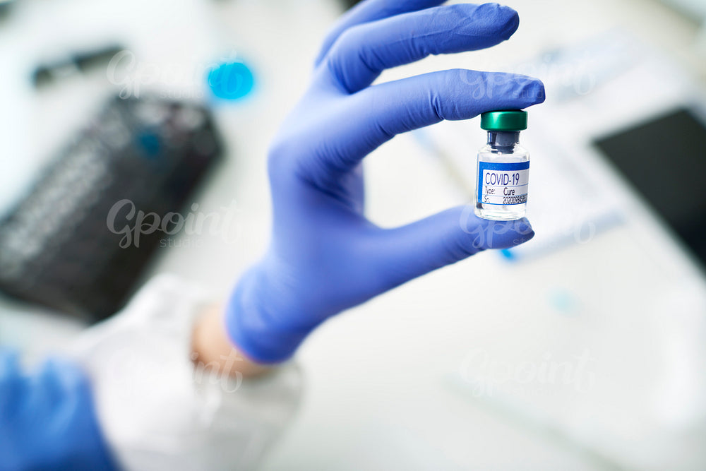 Technician holding an ampule with coronavirus cure