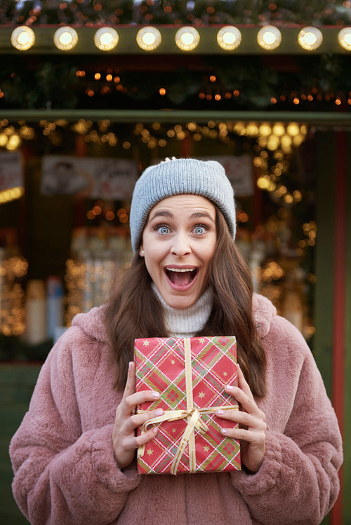Surprised woman with Christmas gifts on Christmas market