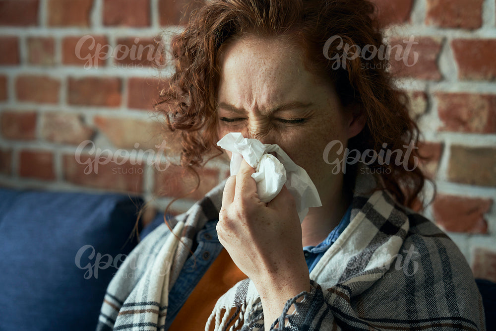 Close up of ill caucasian woman blowing a nose