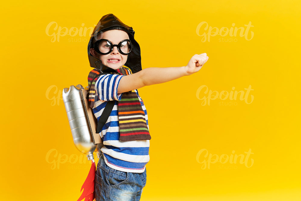 Playful child with jet pack in studio shot
