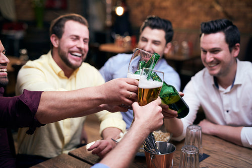 Group of men making a cheers at the bar