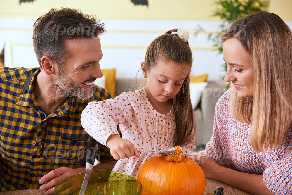 Happy family carving pumpkin for Halloween