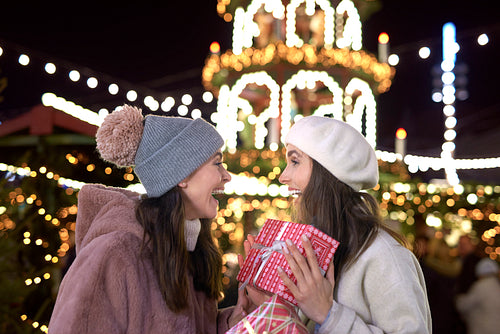 Women exchanging gifts on Christmas market