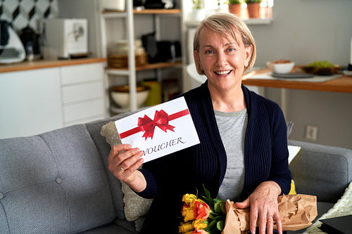 Portrait of mature woman with gift card