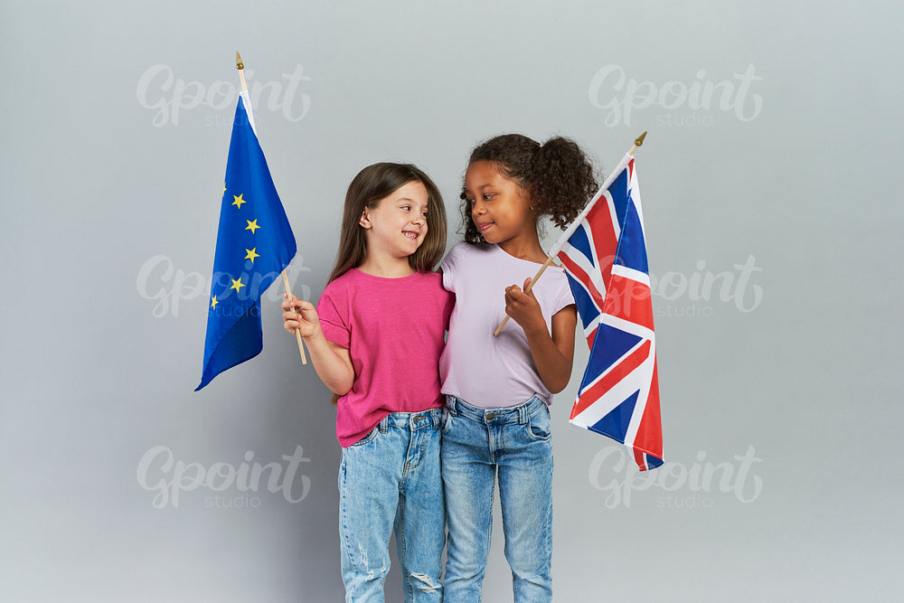 Girls embracing and holding British and European Union flags