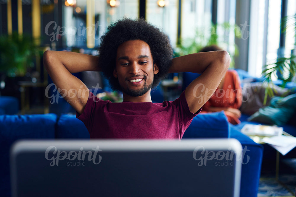Satisfied African man relaxing in the office