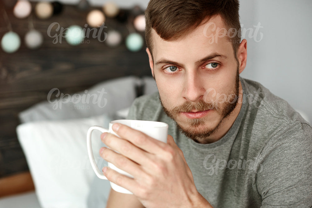 Thoughtful man drinking morning coffee