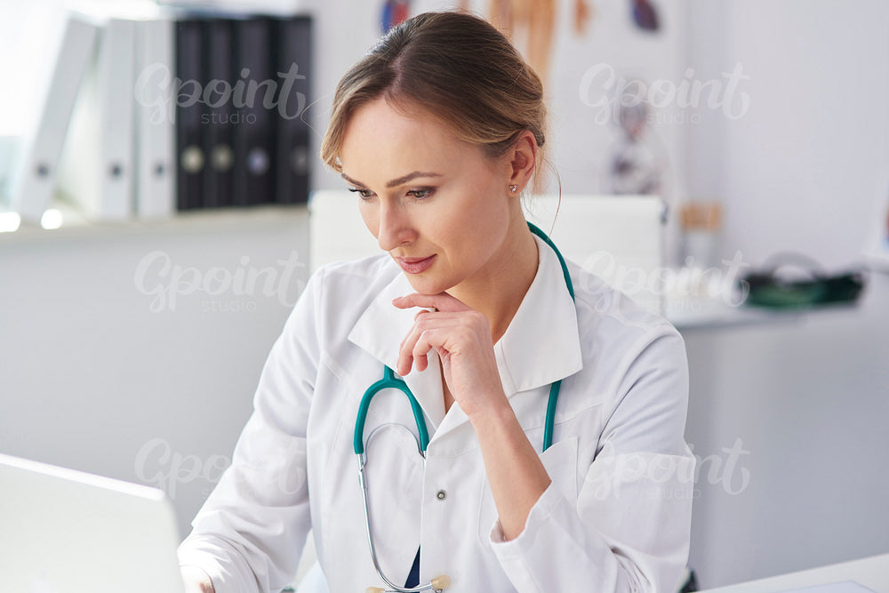 Female doctor working with laptop in her doctor’s office