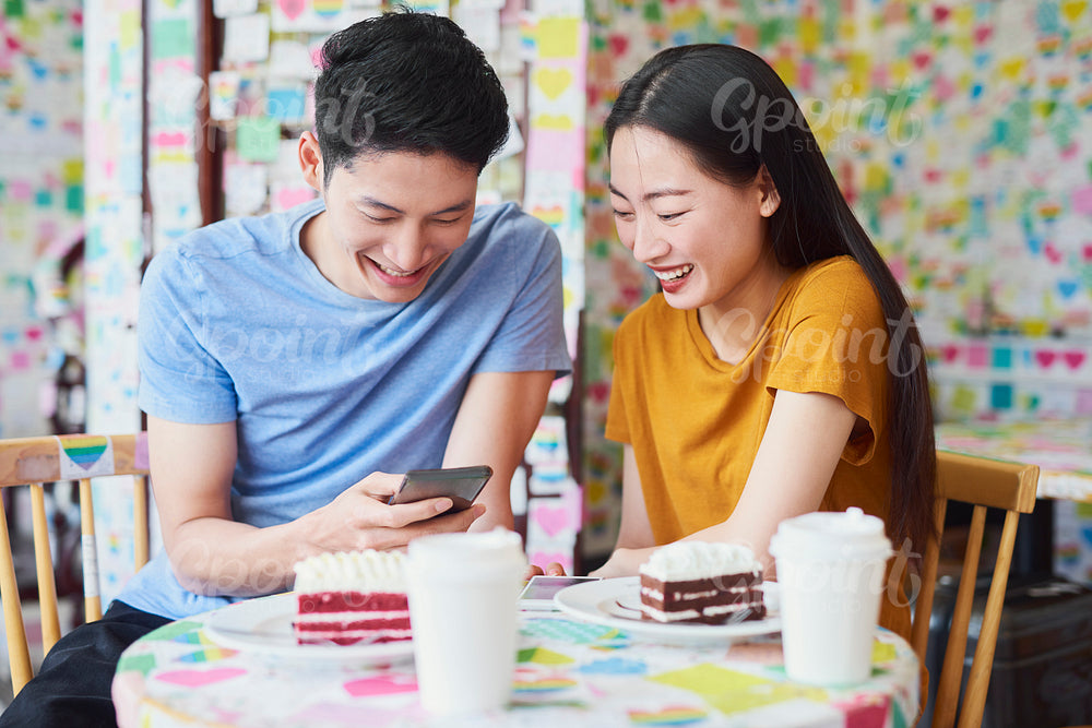 Vietnamese couple enjoying the free internet in a cafe