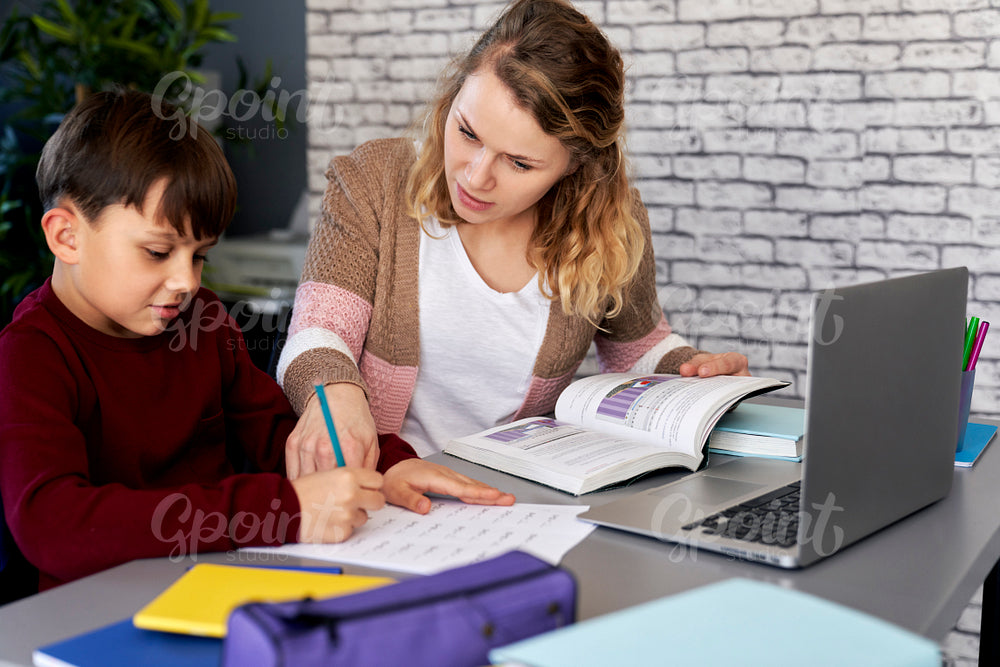 Son with his mother sitting and doing homework