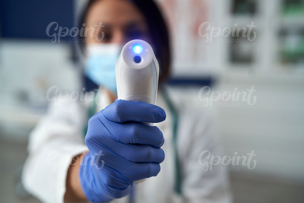 Female doctor checks the temperature of a patient