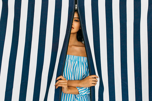 Caucasian woman in striped swimwear looking at camera