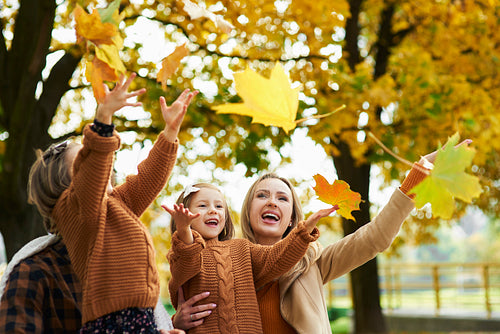 Happy family catching autumnal leafs
