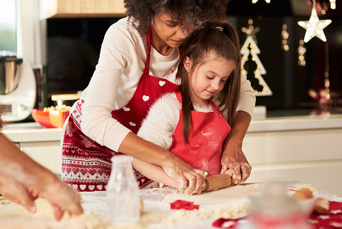 Girl making cookies with mom