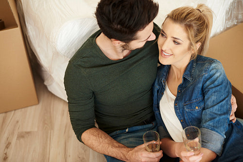 Loving couple toasting new apartment with champagne