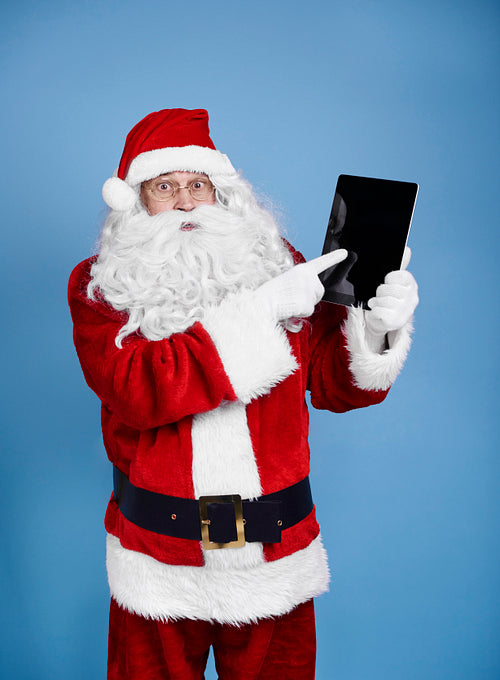 Surprised santa claus holding digital display