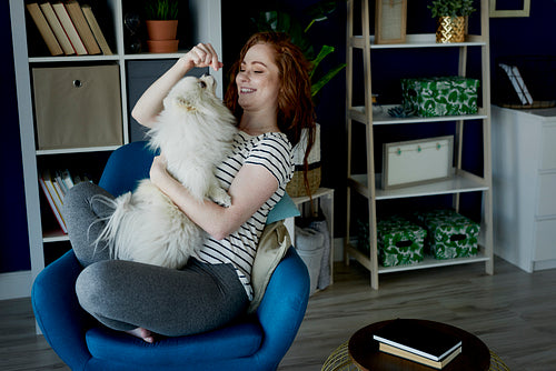 Woman playing with her fluffy dog