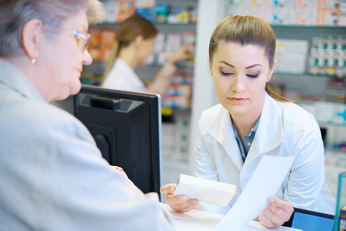 Mature woman discussing product with pharmacist