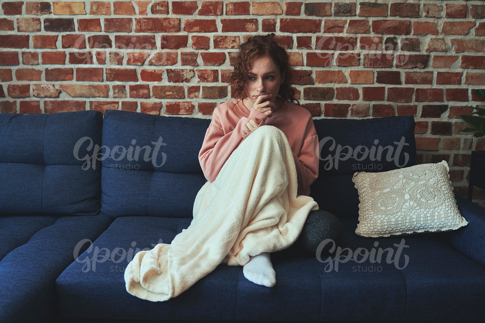 Depressed young caucasian woman sitting in silence on sofa