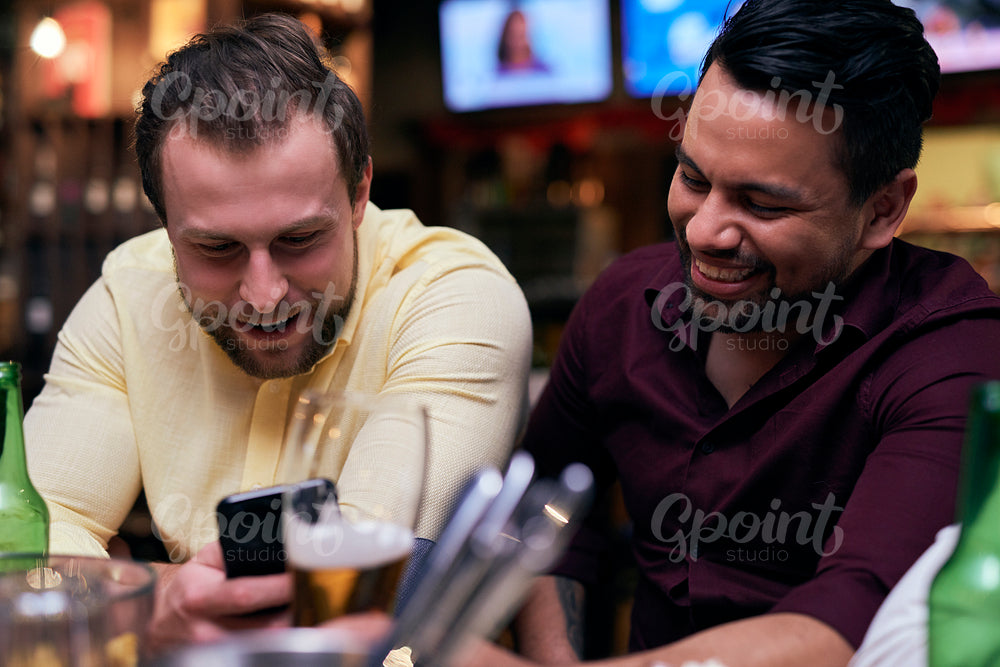 Men using mobile phone at the bar