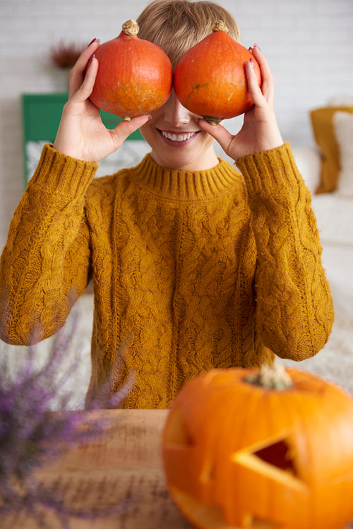 Woman covering her face with pumpkins