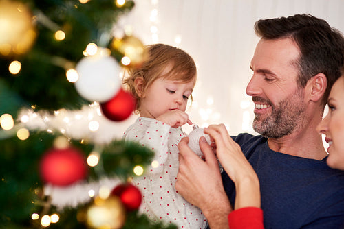 Parents with baby decorating Christmas tree