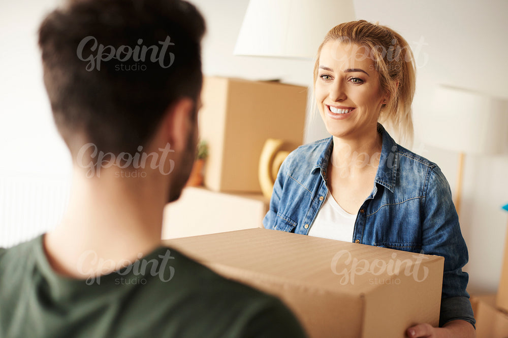 Woman passing cardboard box to her partner