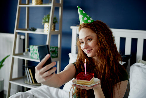Woman taking a selfie with birthday cake