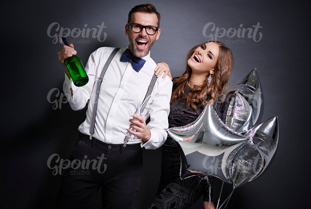Cheerful couple with champagne celebrating new year