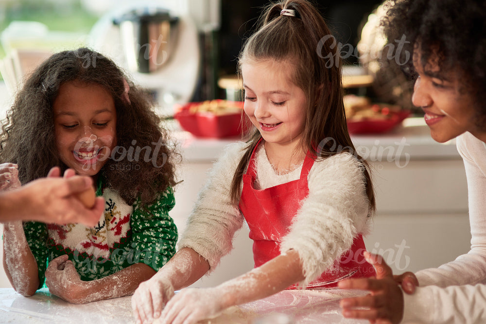 Woman and two girls preparing Christmas cookies
