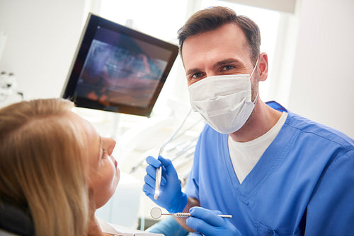 Portrait of confident dentist using dental drill and dental mirror