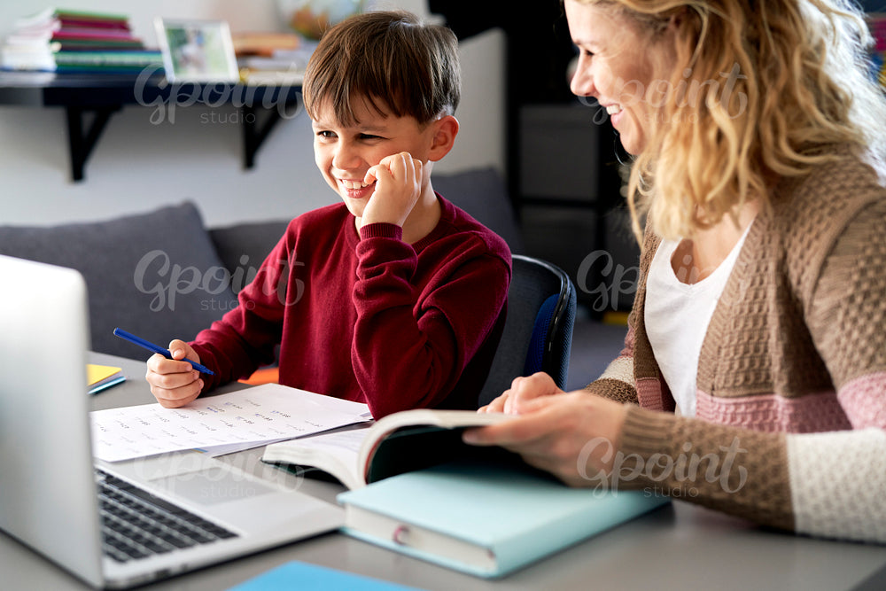 Happy mother and son doing homework together